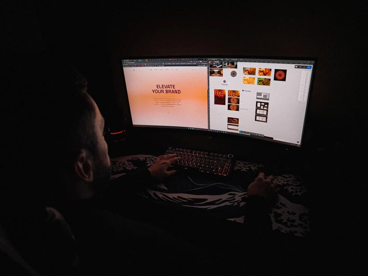 A landing page and the Voyant moodboard open side by side on the monitor at night