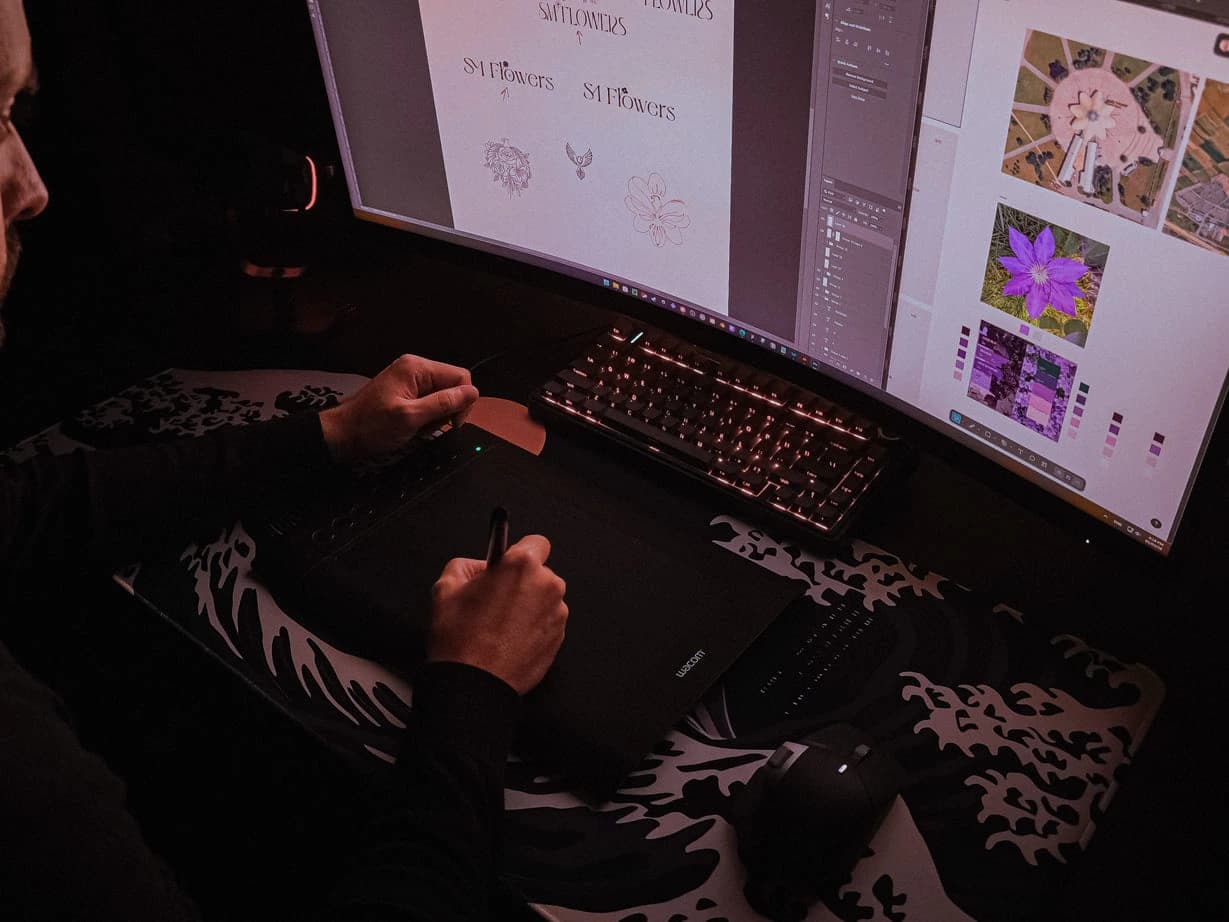 Drawing logo marks on a pen tablet, the sketches open on the screen above